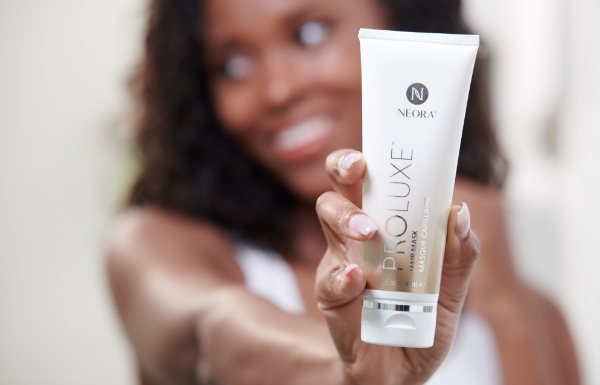 Image of woman holding a tube of ProLuxe Hair Mask out in front of her.