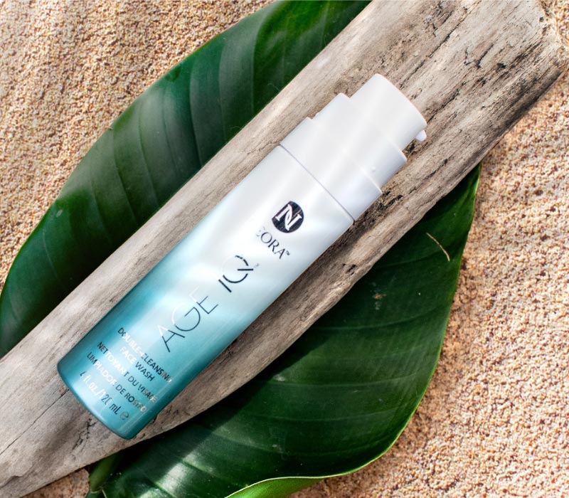 Neora’s gentle Age IQ® Double-Cleansing Face Wash laying on a wooden plan on top of a leaf on the ground